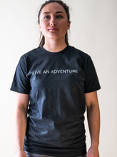Load image into Gallery viewer, model showing black live an adventure glacier rafting t-shirt