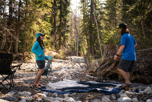 Load image into Gallery viewer, setting up a tent in glacier raft company clothing and merchandise