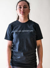 Load image into Gallery viewer, model showing black live an adventure glacier rafting t-shirt
